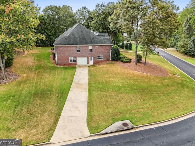 exterior space with driveway, roof with shingles, an attached garage, a yard, and brick siding