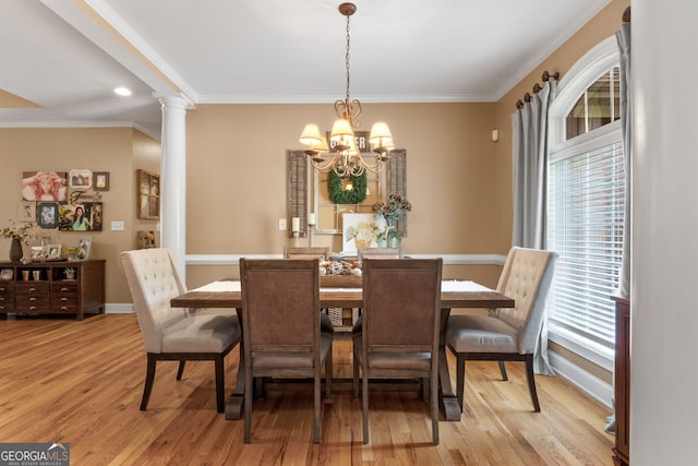 dining area featuring decorative columns, light wood-style floors, ornamental molding, a chandelier, and baseboards