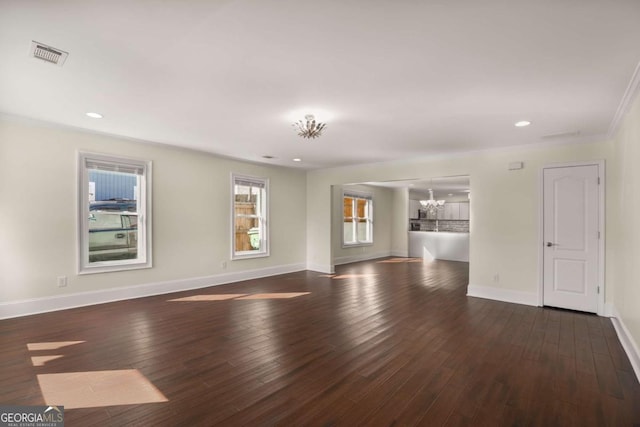 empty room featuring visible vents, baseboards, a notable chandelier, and hardwood / wood-style floors