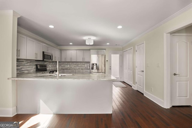 kitchen featuring dark wood-style floors, gray cabinets, appliances with stainless steel finishes, and a peninsula