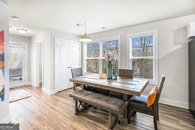 dining area featuring light wood-type flooring, visible vents, and baseboards