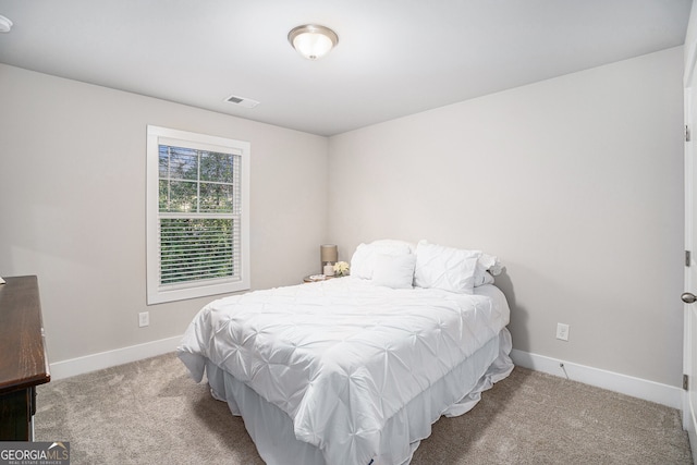 carpeted bedroom featuring baseboards and visible vents