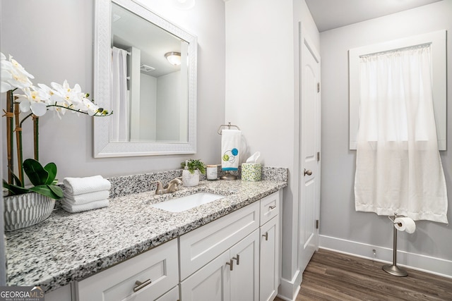 bathroom with vanity, baseboards, and wood finished floors