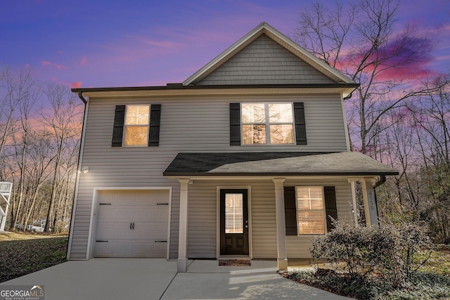 view of front of property with a garage, driveway, and a porch