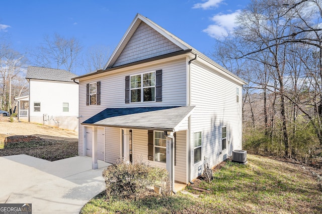 view of front facade featuring covered porch, driveway, central AC unit, and an attached garage