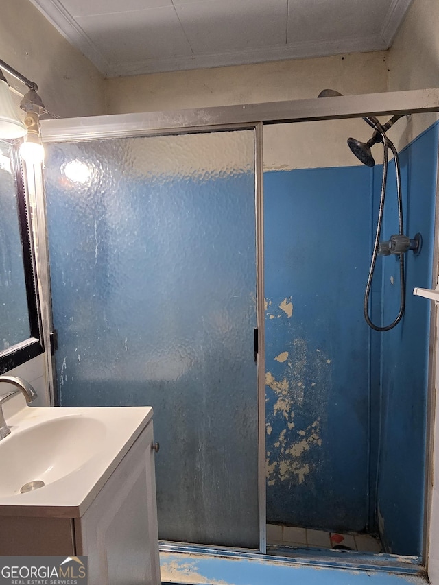 bathroom featuring ornamental molding, a shower stall, and vanity