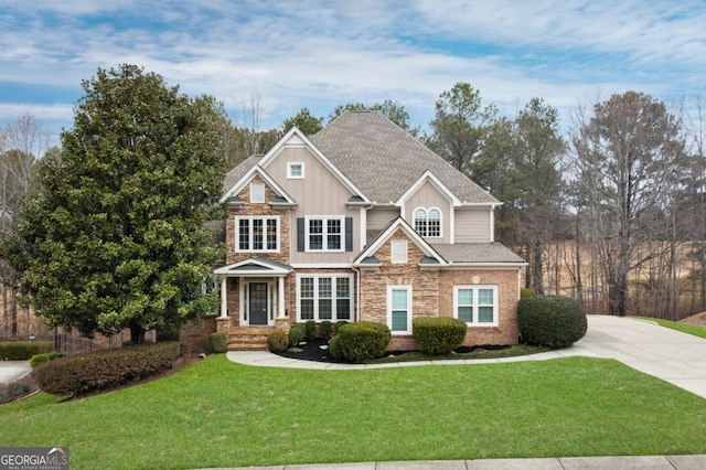 craftsman-style home featuring roof with shingles, a front lawn, board and batten siding, and stone siding