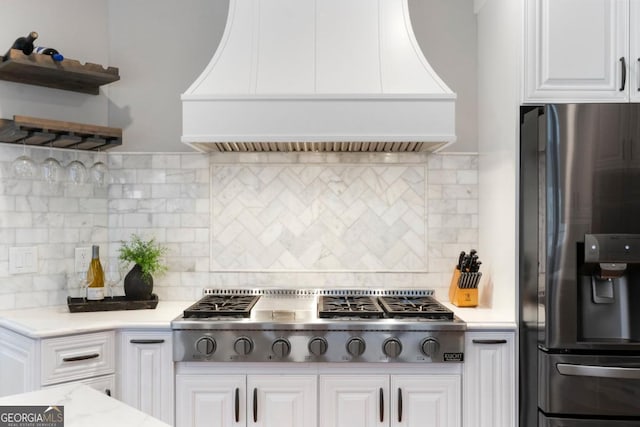 kitchen with open shelves, appliances with stainless steel finishes, white cabinets, and custom range hood