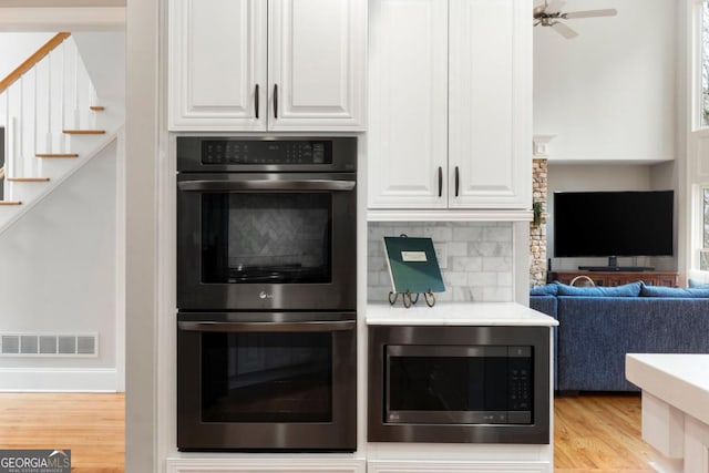 kitchen featuring light wood-type flooring, white cabinetry, visible vents, and appliances with stainless steel finishes