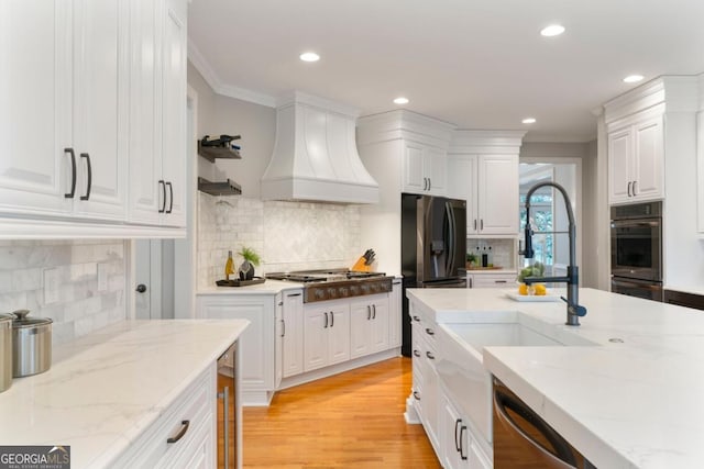 kitchen featuring stainless steel gas cooktop, premium range hood, ornamental molding, and white cabinets