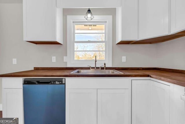 kitchen with white cabinets, dishwasher, butcher block counters, decorative light fixtures, and a sink