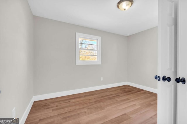 empty room featuring baseboards and wood finished floors