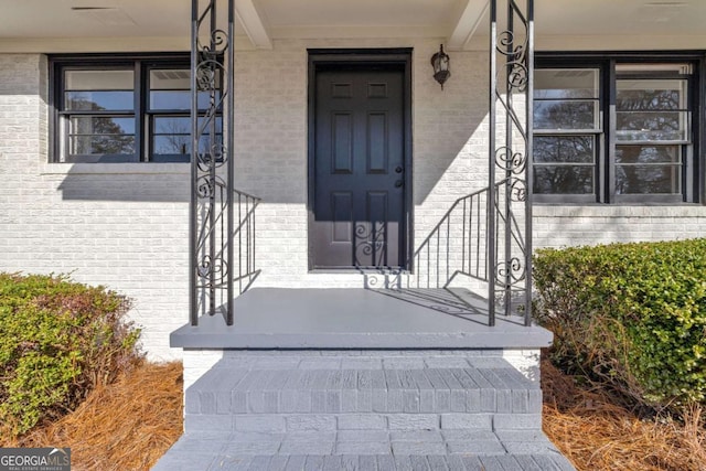 view of exterior entry with brick siding