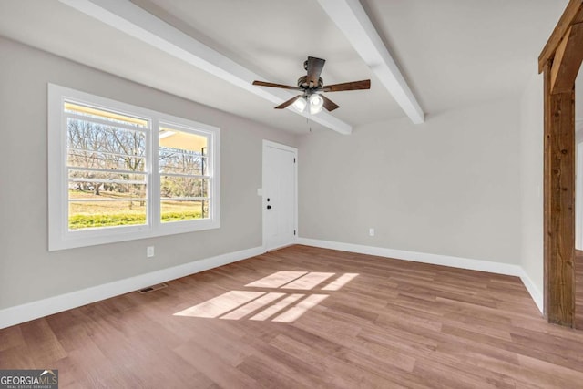 unfurnished bedroom featuring light wood-style floors, beam ceiling, and baseboards