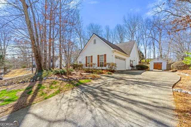 view of side of property featuring an attached garage and aphalt driveway