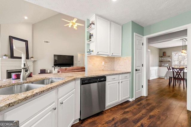 kitchen featuring a fireplace, stainless steel dishwasher, dark wood-type flooring, white cabinets, and a sink