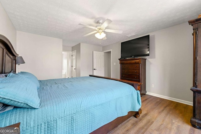 bedroom with ceiling fan, a textured ceiling, baseboards, and wood finished floors