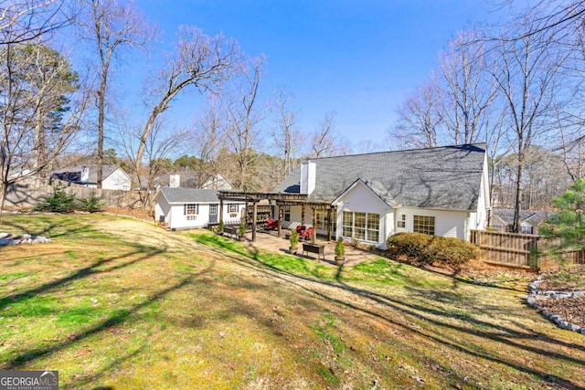 back of property featuring a yard, a patio, fence, a pergola, and an outdoor structure