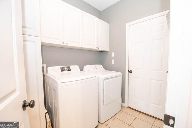 washroom featuring cabinet space, independent washer and dryer, and light tile patterned floors