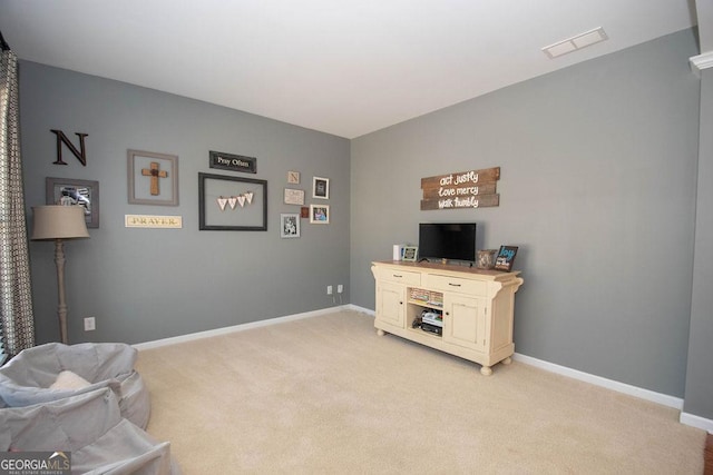 sitting room with baseboards, visible vents, and light colored carpet