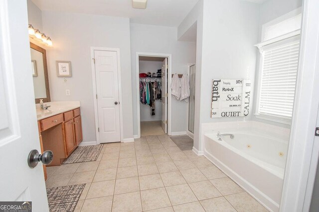 full bath with baseboards, a tub with jets, tile patterned floors, vanity, and a shower stall