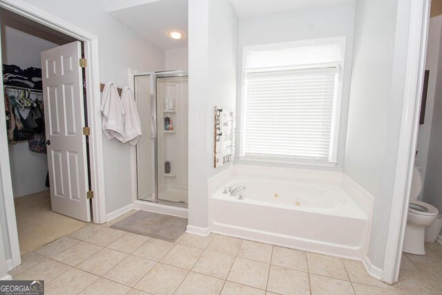 full bathroom featuring a stall shower, a whirlpool tub, toilet, and tile patterned floors