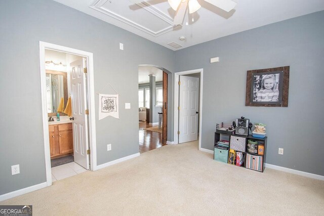 interior space with light carpet, baseboards, arched walkways, and ensuite bathroom