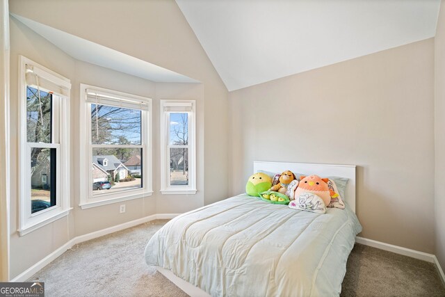 bedroom featuring lofted ceiling, baseboards, and carpet floors