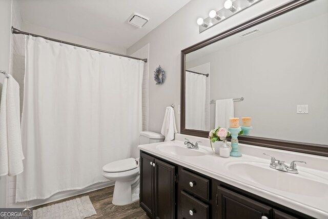 full bathroom featuring double vanity, visible vents, toilet, and a sink