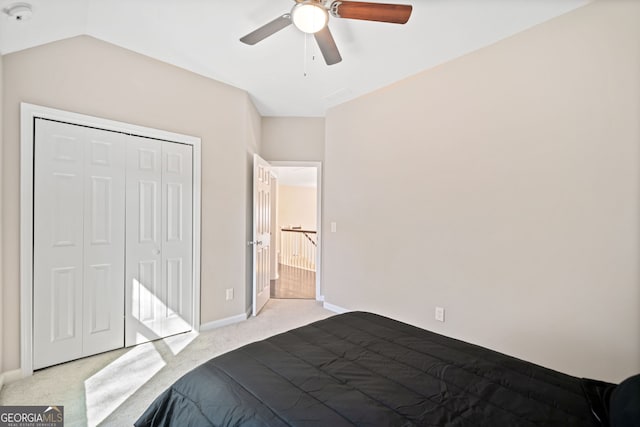 bedroom with light carpet, a ceiling fan, a closet, baseboards, and vaulted ceiling