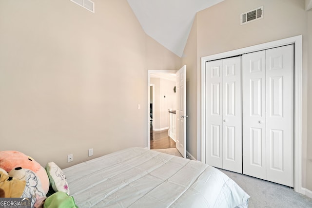 carpeted bedroom featuring a closet, visible vents, high vaulted ceiling, and baseboards