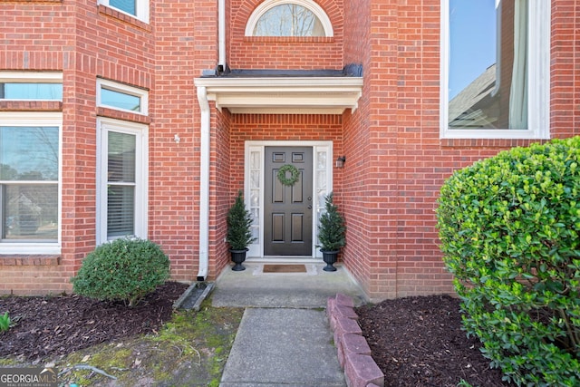 doorway to property with brick siding