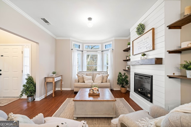 living room with dark wood-style floors, visible vents, a fireplace, and ornamental molding