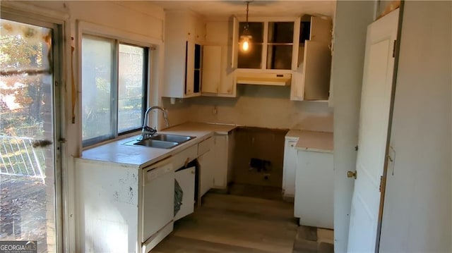 kitchen with pendant lighting, light countertops, white dishwasher, a sink, and under cabinet range hood