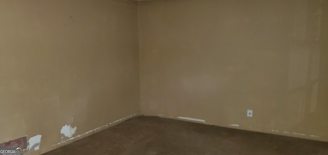 unfurnished room with dark colored carpet