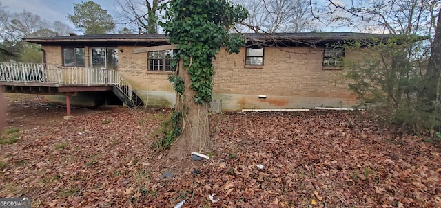 exterior space featuring crawl space, a wooden deck, and brick siding