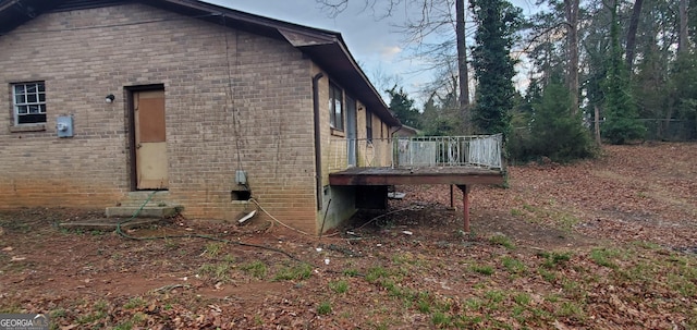 view of property exterior featuring a wooden deck and brick siding