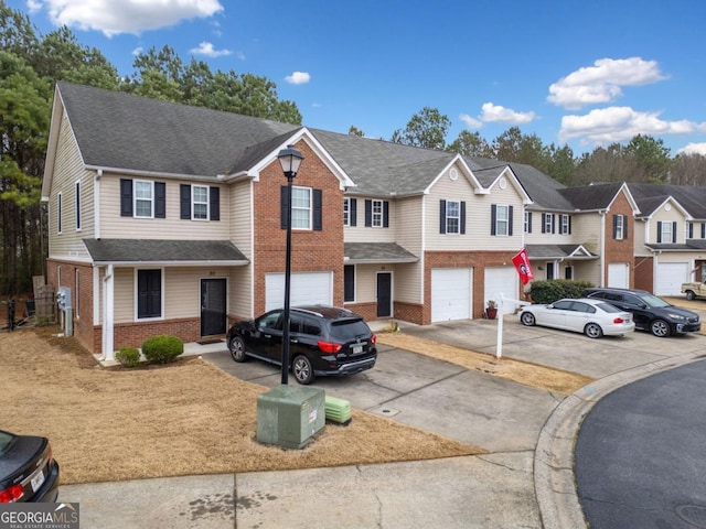 townhome / multi-family property with brick siding, a shingled roof, a garage, a residential view, and driveway