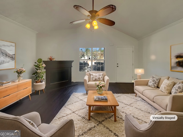 living room with crown molding, lofted ceiling, a fireplace with raised hearth, ceiling fan, and wood finished floors