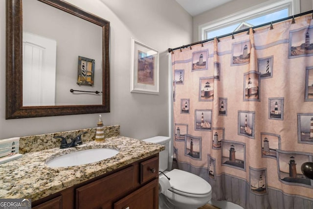 full bathroom featuring a shower with shower curtain, vanity, and toilet