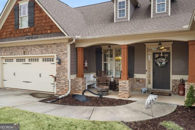 property entrance with driveway, covered porch, a shingled roof, and stone siding