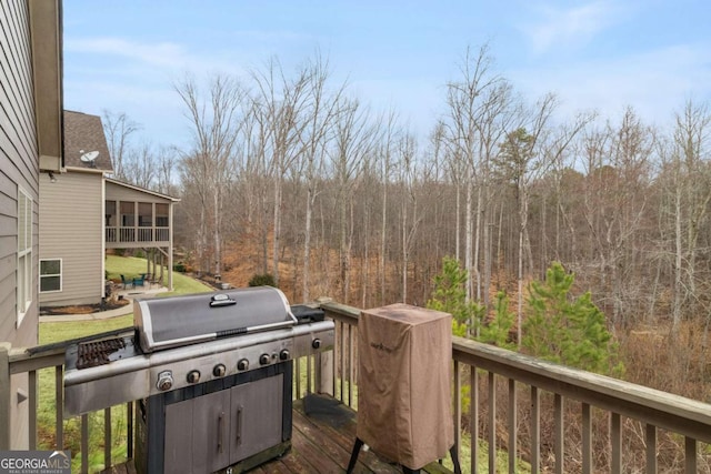 wooden terrace featuring a view of trees