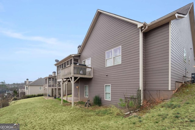 back of property with a deck and a lawn