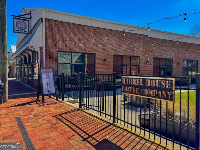 exterior space featuring brick siding and fence