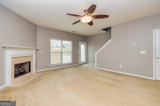 unfurnished living room with light carpet, visible vents, a fireplace, and baseboards