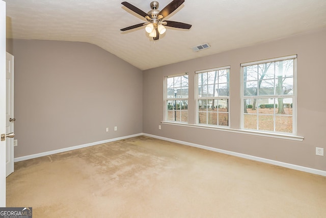 spare room with a wealth of natural light, visible vents, vaulted ceiling, and baseboards