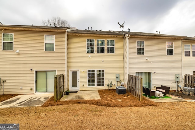 back of property with a patio and central AC