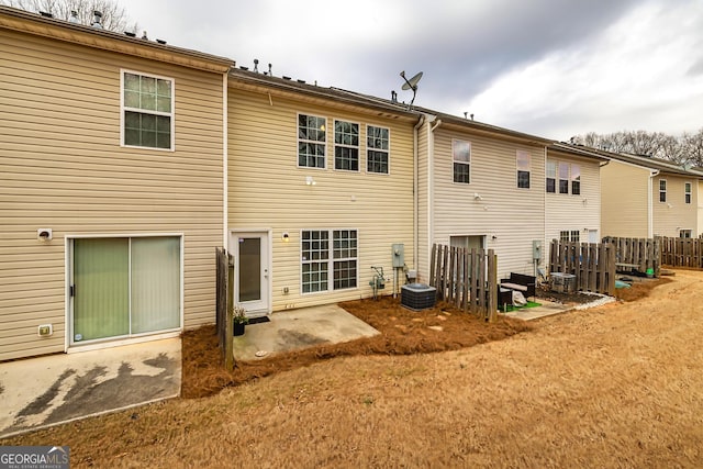 rear view of property featuring a patio area, fence, and central AC unit