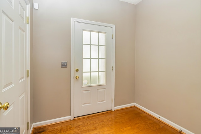 doorway to outside with light wood-style flooring and baseboards