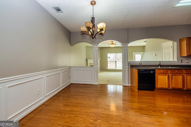 kitchen with ceiling fan with notable chandelier, a sink, visible vents, black dishwasher, and brown cabinets